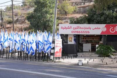 Image for Israeli settlers flank Palestinian cafe with dozens of Israeli flags