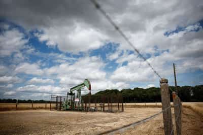 Image for Oil edges down on easing Middle East risks but gains for a second month