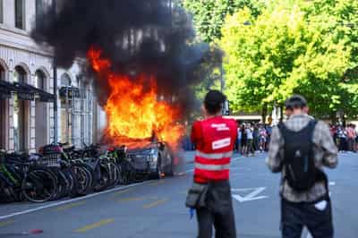 Image for Protesters smash windows and set Tesla ablaze in anti-G7 march in Geneva