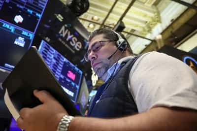 Image for Wall St dips and gold surges, capping a tumultuous week